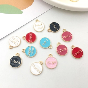 Detail view of 12 colorful double-sided enamel zodiac charms with gold borders for DIY jewelry