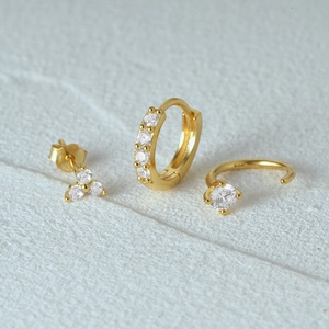 Macro shot of gold S925 sterling silver three-piece earring set with turquoise and zircons