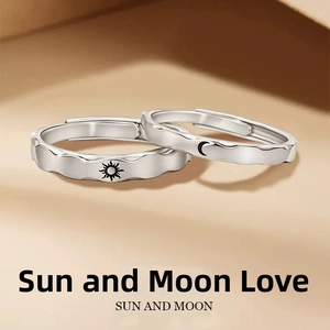 Detail of adjustable couple rings with sun and moon totems on wave-edged silver bands