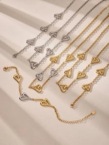 Dettaglio di bracciali a cuore in acciaio inossidabile nei colori oro, argento e bicolore