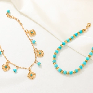 Two-piece turquoise and gold bead bracelet set with hollow flower charm on silk