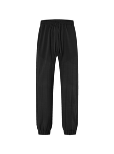 Detail of black jogger pants featuring striped texture contrast and elastic cuffs