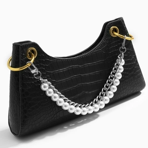 Black crocodile texture handbag with pearl and silver chain strap on white background