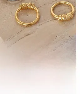 Detailed shot of two gold-plated titanium steel rings with organic twisted knot design