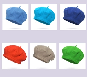 Close-up of wool beret hats in blue, red, khaki, and green felt textures