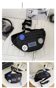 Close-up of black nylon chest bag with decorative fashion patches and adjustable buckle strap