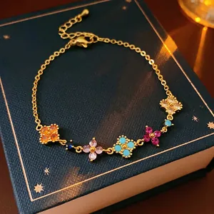 Gold plated bracelet with colorful zircon clover charms on a luxury jewelry box