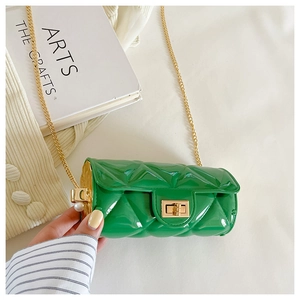 Detail of green quilted patent leather mini bag with gold chain and pearl accent