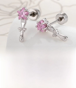 Macro detail of silver star-shaped pink zircon cartilage studs with flat screw backs