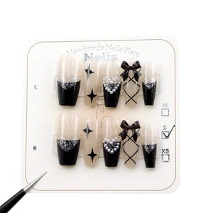 Handmade press-on nails set with black bows, silver glitter, and gothic heart designs