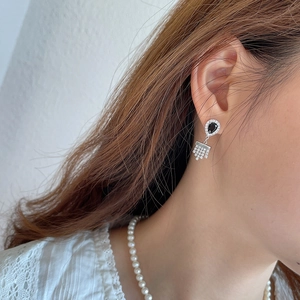 Silver drop earrings with black stones and zircon tassels on a female model