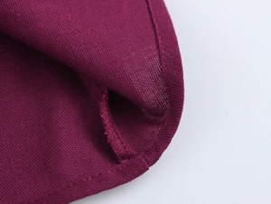 Gros plan sur la robe en tricot bordeaux montrant la texture et les coutures de qualité