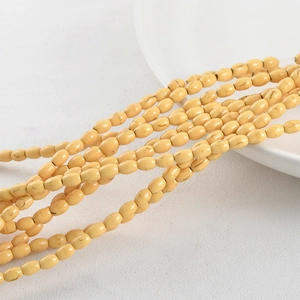 Macro shot of oval turquoise beads with natural brown texture on white ceramic plate