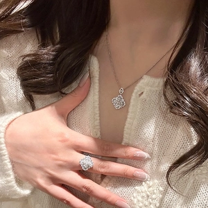 Detail of silver clover jewelry set with micro-pave crystals on necklace and ring