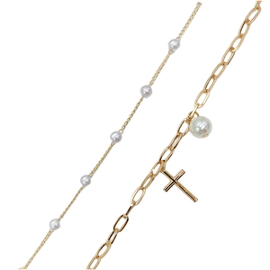 Detail of gold double-layer necklace featuring white pearls and a cross pendant charm