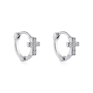 Vue macro de boucles d'oreilles créoles croix en argent avec des pierres de zircon blanc