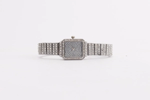 Close-up of a silver square-faced women's watch with shimmering crystal detailing