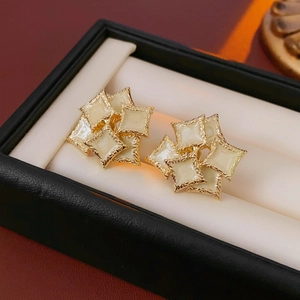 Macro detail of French vintage square enamel stud earrings on luxury display box