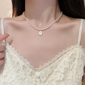 Vintage tulip pearl necklace with golden oval flower pendant on an elegant woman
