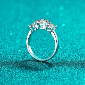 Elegant S925 sterling silver three-stone moissanite ring on glittery blue background
