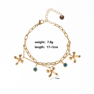 Detailed view of gold double chain bracelet with blue evil eye charms and star pendants