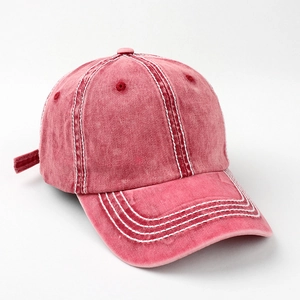 Detail of vintage washed red cotton baseball cap with bold contrast stitching and seams