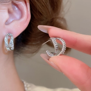 Detailed view of silver double-row C-shaped earrings with micro-pave sparkling crystals