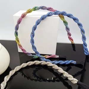 Detail of twisted crystal headbands in rainbow, blue and silver colors with rhinestones