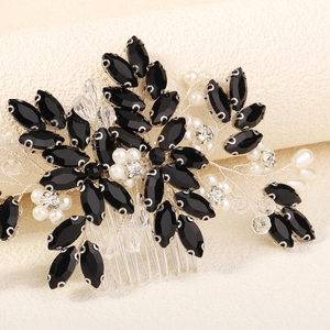 Close-up of handmade bridal hair comb with black stones, pearls and wire details