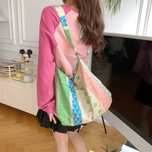 Floral patchwork canvas shoulder bag shown in use to highlight large capacity