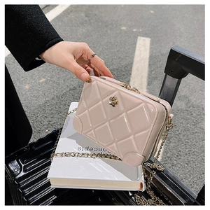 Close-up of pink jelly crossbody bag with quilted diamond pattern and gold chain