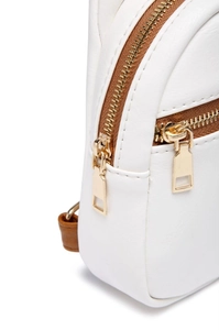 Close-up of golden zipper hardware and brown trim on white leather crossbody bag