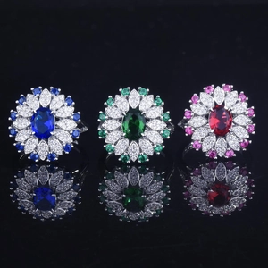 Detailed view of three luxury sunflower rings with sapphire, emerald and ruby gems
