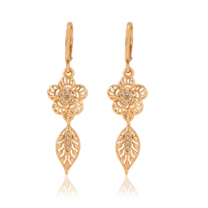 Detail of gold floral earrings featuring hollow leaves and sparkling cubic zirconia crystals
