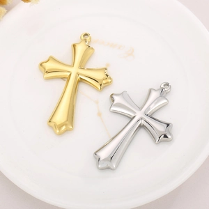 Pendentifs de collier croix tendance en or et argent posés sur une assiette décorative