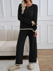 Detail of black knit set with yellow trim featuring long sleeves and wide leg trousers