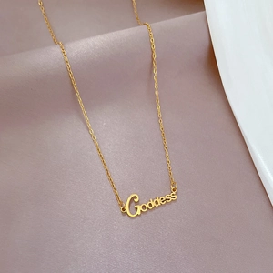 Close-up of Goddess pendant on a thin gold titanium steel chain over silk fabric