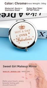 Detail of chrome-finished stainless steel compact mirror with crown emblem and engraving