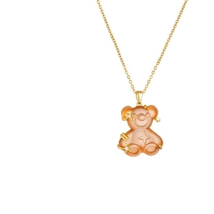 Macro detail of a resin bear pendant with star and moon elements on a gold chain