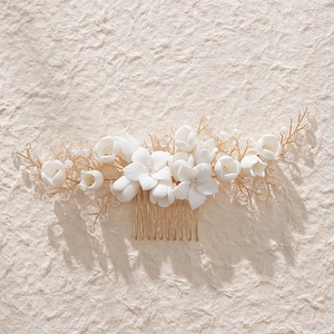 Handmade bridal hair comb featuring white ceramic flowers, gold wire, pearls and crystals