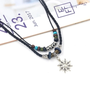 Close-up of a tribal leather necklace with sun pendant, colorful beads, and silver accents
