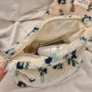 Detail of plush floral cosmetic bag showing metal zipper and spacious interior storage