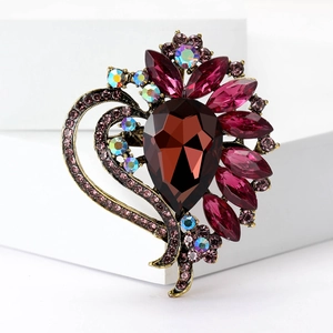 Macro shot of a vintage teardrop ruby gemstone brooch with purple rhinestone details