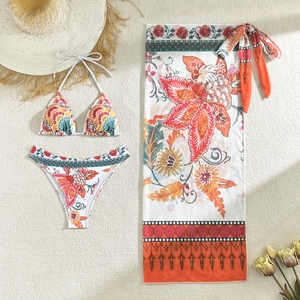 Three-piece floral bikini set with halter top, bottom, and matching beach sarong wrap