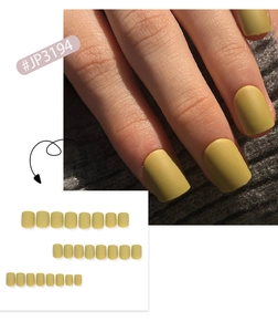 Detail view of mustard yellow matte press-on nails on fingers and full set layout.