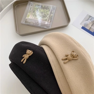 Detail of wool beret with cute 3D bear ornament in black and beige twill texture
