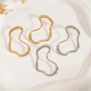 Minimalist irregular geometric metal earrings in gold and silver finish on ceramic tray