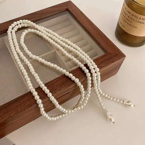 Collier de perles vintage avec pendentifs baroques sur boîte à bijoux en bois