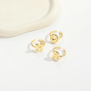 Minimalist gold plated adjustable letter rings H O R on white stone display