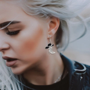Close-up of model wearing silver western cowboy boot and hat earrings with zircons